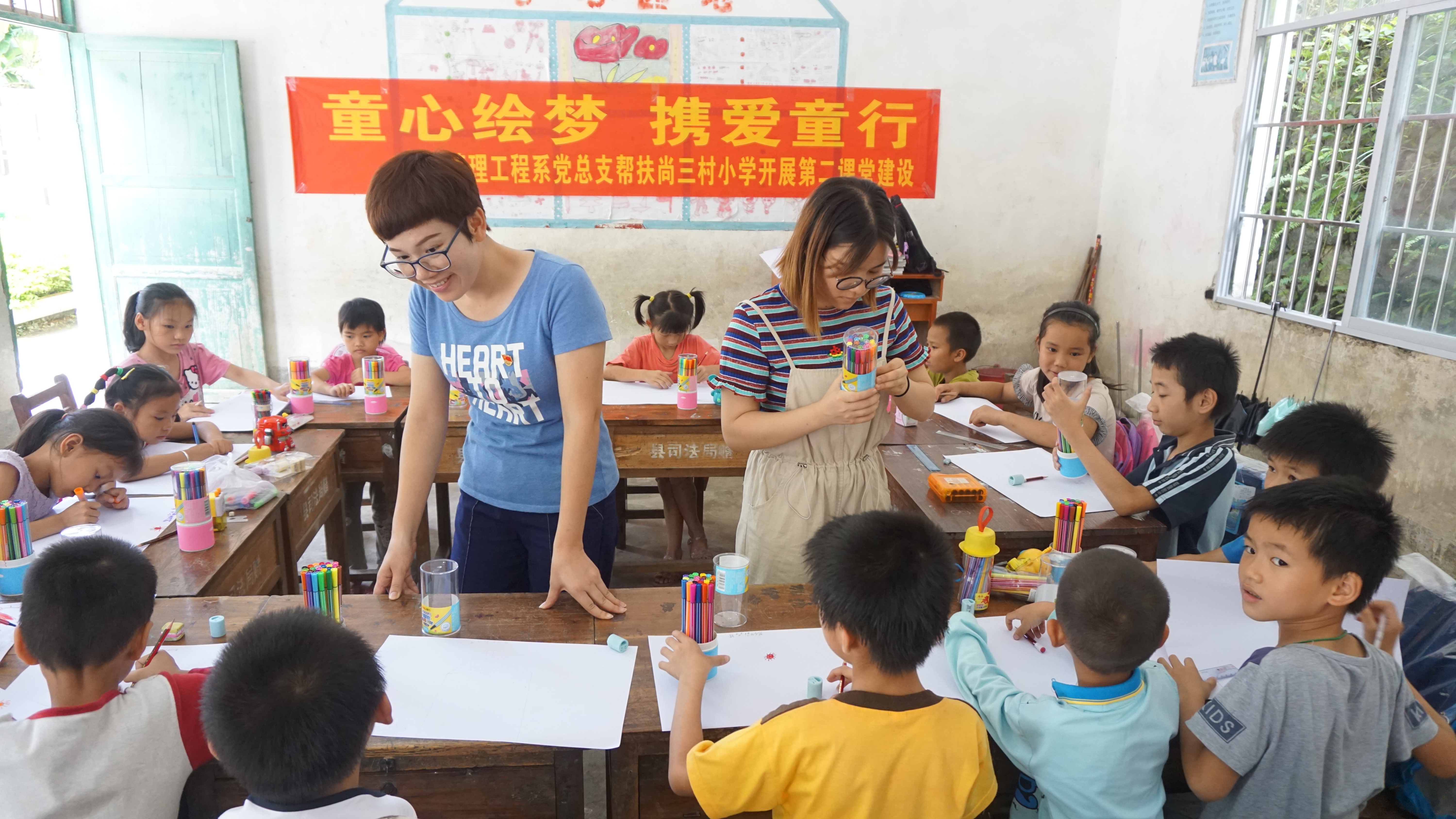 何丽梅和卢美凤两位老师在引导小朋友们作画