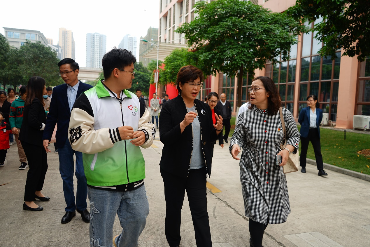 自治区残联党组书记、理事长黄丽娟（中）与完美网页版设备学院党总支书记侯文淑（右）对活动进行深入沟通交流